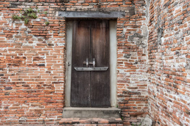 istock wooden door on old brick wall, Ayutthaya 1013725556