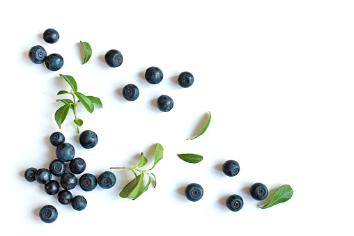 Fresh blueberries with green leaves leaves, organic blueberry border pattern isolated on white background, top view.