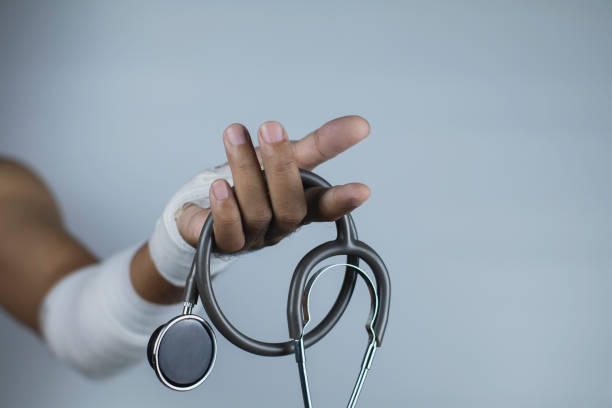 stéthoscope, plaies au niveau du poignet, bandages une médecine de la douleur main plaie, fracture du bras de blessés après l’accident, l’attelle bras pour concept de traitement, de blessures et de la santé. - joueur de champ gauche photos et images de collection