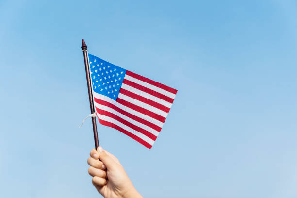 istock Unknown child holding an American flag 1013734314