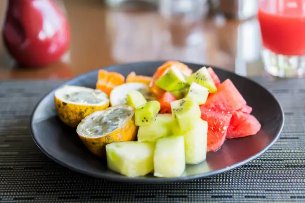 Close up of assorted fresh fruit slices on the plate served for dessert