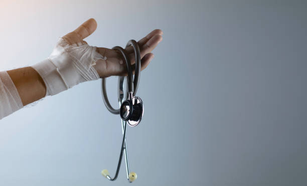 stéthoscope, plaies au niveau du poignet, bandages une médecine de la douleur main plaie, fracture du bras de blessés après l’accident, l’attelle bras pour concept de traitement, de blessures et de la santé. - joueur de champ gauche photos et images de collection