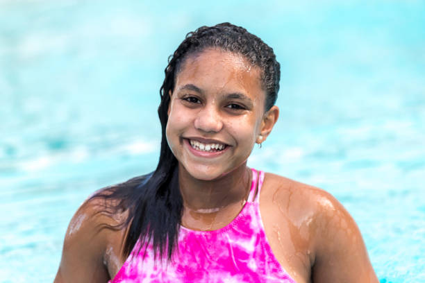 hermosa chica adolescente sonriente en la piscina - early teens child swimming pool swimming fotografías e imágenes de stock