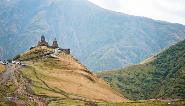 istock Caucasus mountains, ancient Gergeti Trinity church Tsminda Sameba against the glacier near mount Kazbek, landmark of Georgia 1013744648