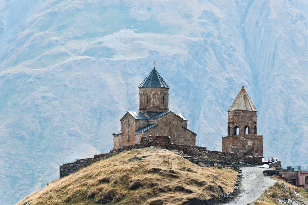 istock Caucasus mountains, ancient Gergeti Trinity church Tsminda Sameba against the glacier near mount Kazbek, landmark of Georgia 1013744658