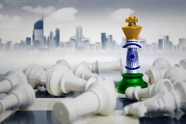 Image of a chess king with India flag defeating white chess pieces. Shot with modern city