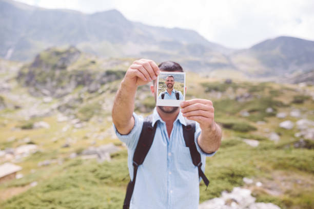 istock Man in the mountain showing instant photo 1013756952