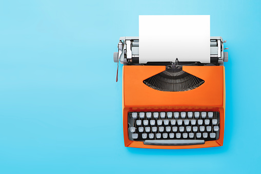 Máquina de escribir en estilo retro sobre fondo azul. photo