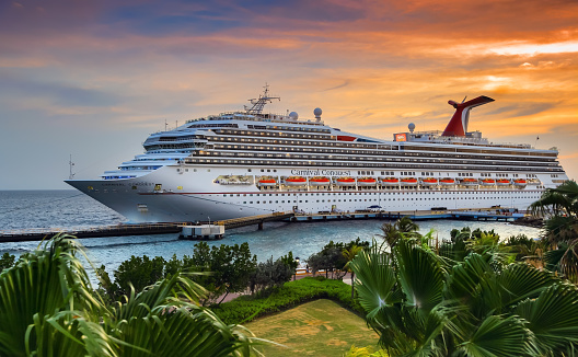 WILLEMSTAD, CURACAO - APRIL 04, 2018:  Cruise ship Carnival Conquest docked at port Willemstad on sunset.  The island is a popular Caribbean cruise destination