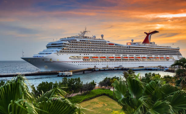 Cruise Ship in port WILLEMSTAD, CURACAO - APRIL 04, 2018:  Cruise ship Carnival Conquest docked at port Willemstad on sunset.  The island is a popular Caribbean cruise destination willemstad stock pictures, royalty-free photos & images