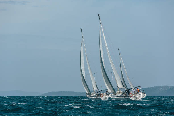 istock Three yachts sail boats racing in a blue sea 1013765212