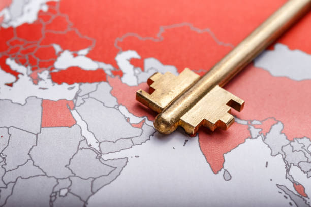 key from the modern door on the contour map of the world. - skeleton key imagens e fotografias de stock