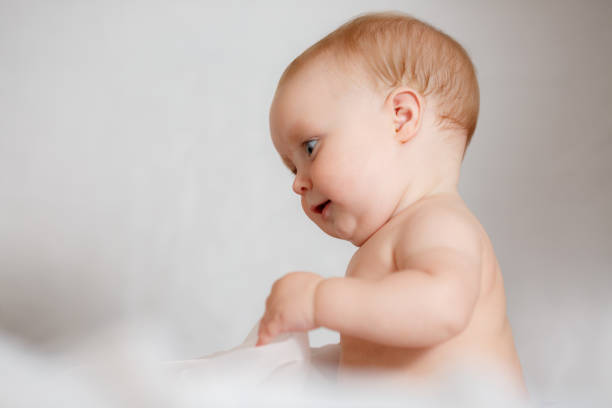 istock A Baby girl in white bedding at home look nice 1013773484