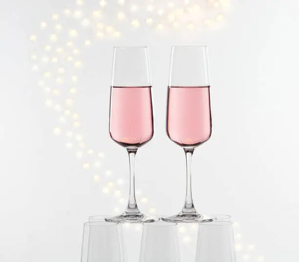Two glasses of pink champagne on glass pyramid in front of star decoration