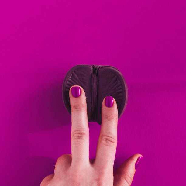 Vagina concept on purple background Vagina symbol. Two fingers on chocolate orange on purple background. Minimalism concept. Top view, copy space, square chocolate fingers stock pictures, royalty-free photos & images