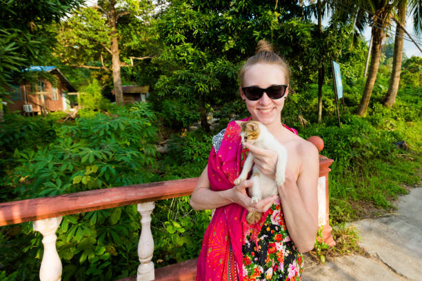 Girl tourist with cat on tropical Tioman island in Malaysia. Travelling in south east asia.