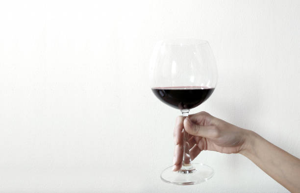istock woman hand with wine glass on a white background. 1013788662