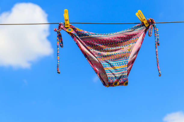 istock Drying female swimsuit hanging on a rope against blue sky 1013789320