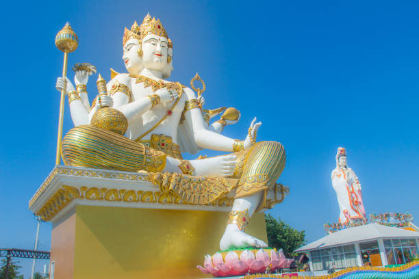 istock Giant white Brahma statue with blue sky background. Brahma is the Hindu Creator god. He is also known as the Grandfather and supreme in the triad of great Hindu gods which includes Shiva and Vishnu. 1013791706