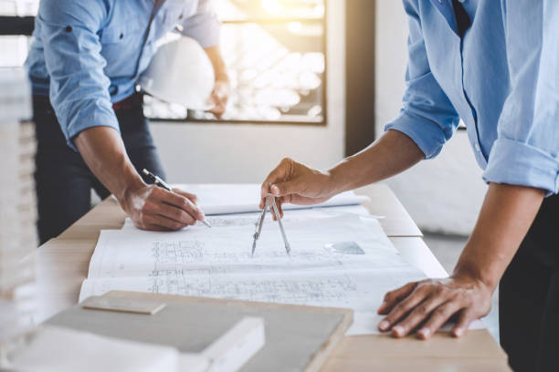 istock Hands of architect or engineer working on blueprint meeting for project working with partner on model building and engineering tools in working site, Construction concept 1013792050