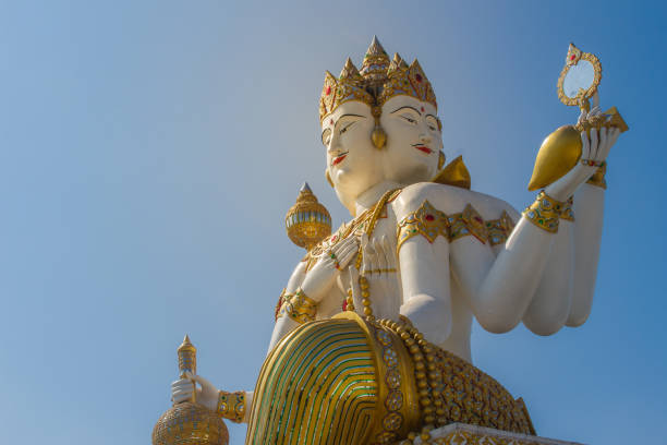 istock Giant white Brahma statue with blue sky background. Brahma is the Hindu Creator god. He is also known as the Grandfather and supreme in the triad of great Hindu gods which includes Shiva and Vishnu. 1013795948