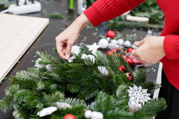 istock A woman decorates a Christmas wreath. Hands close-up. Master class on making decorative ornaments. Christmas decor with their own hands. The new year celebration. Flower shop 1013805996