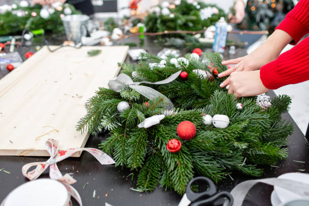 istock A woman decorates a Christmas wreath. Hands close-up. Master class on making decorative ornaments. Christmas decor with their own hands. The new year celebration. Flower shop 1013806974