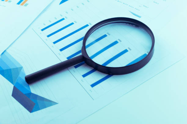 istock Business Analysis and Statistics Reports from sales charts last year using a magnifying glass. 1013807078