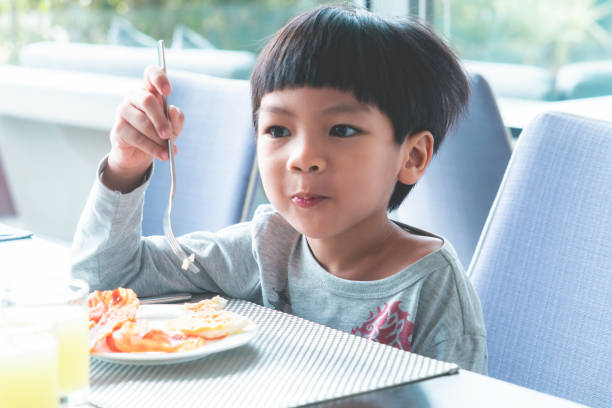 istock Asian boy is having breakfast in cafe 1013809542