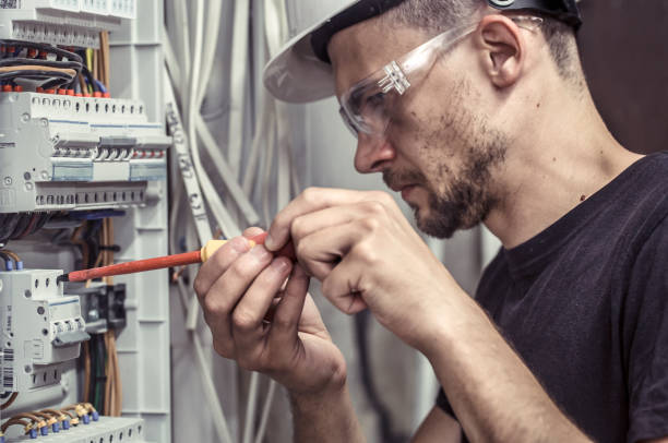istock a male electrician works in a switchboard with an electrical connecting cable 1013823412