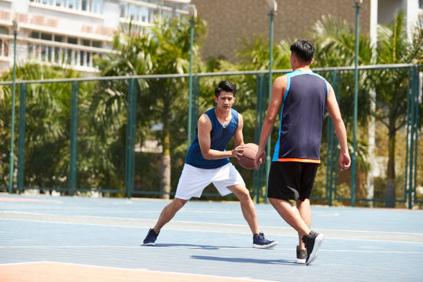 istock asian young adults playing basketball 1013823448