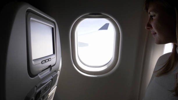 istock CLOSE UP: Content businesswoman on transatlantic flight looks through her window 1013829484