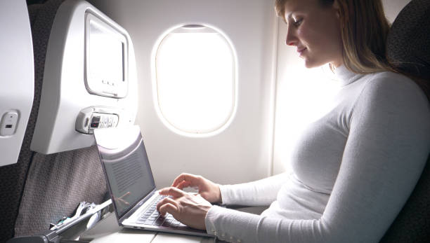 istock CLOSE UP: Happy journalist writing a blog post during her transatlantic flight. 1013829486