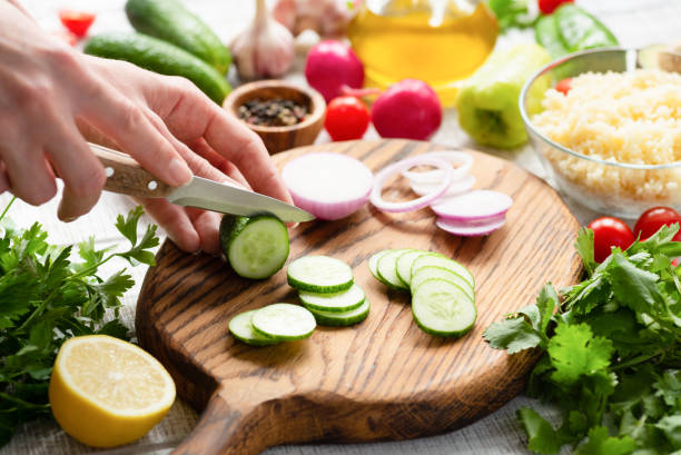 istock Preparing salad. Female chef cutting fresh vegetables 1013834248