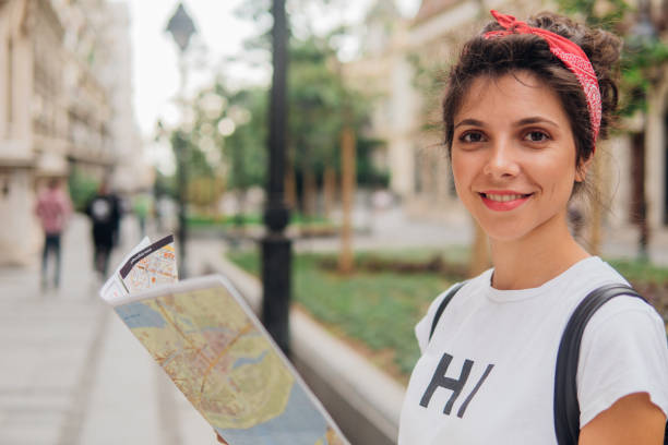 istock Young woman holding touristic map and smiling 1013847292
