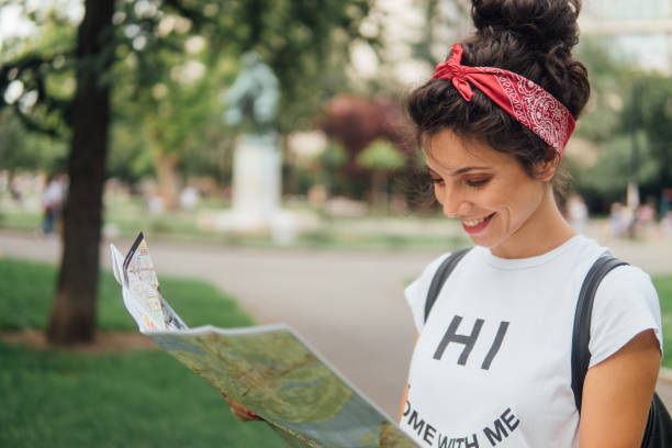 istock Happy young woman reading thye map and smiling 1013847294