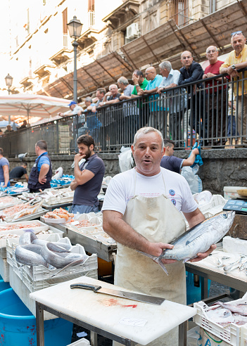 Catania, Sicily, Italy - July 1st, 2014:  The fast paced and loud fish market always attracts large crowd, locals and tourists alike, It’s one of the most visited places in the city by visitors.