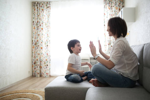 istock beautiful brunette mom and son hugging on sofa 1013853528