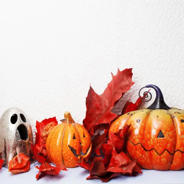 Happy Halloween. Festive still life, pumpkin-lantern and autumn leaves. White background, copy space