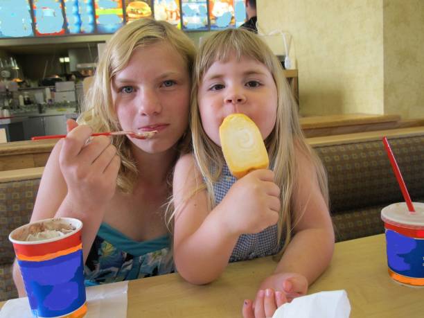 istock 2 girls eating ice cream at restaurant 1013863890