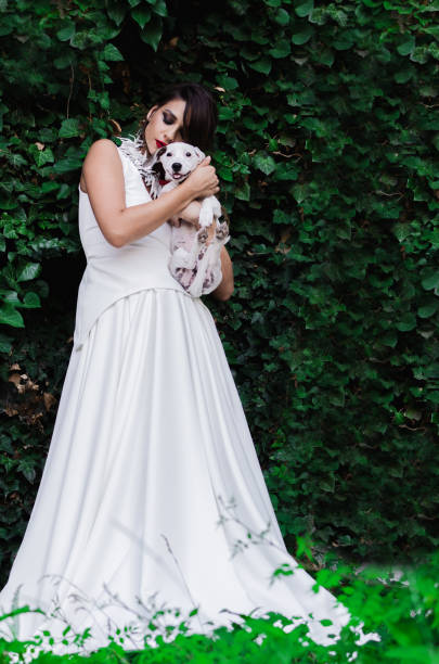 istock Woman in white long dress hugging dog 1013870878