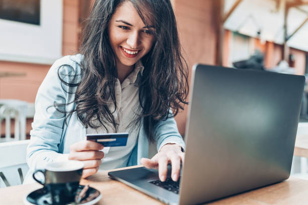 mujer joven con laptop y tarjeta de crédito en la cafetería - cafe laptop espresso business fotografías e imágenes de stock