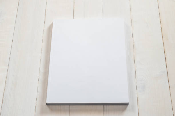 istock Blank book cover mockup template with page front side on white surface on wood table 1013913712