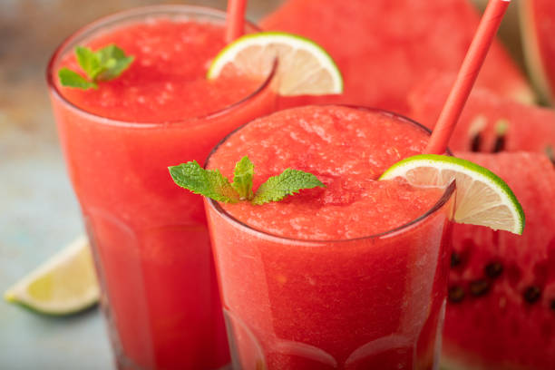 istock Watermelon slushie with lime, summer refreshing drink in tall glasses on a blue rusty background 1013921880