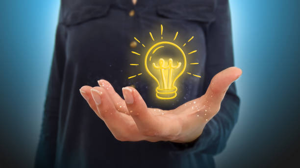istock Businesswoman on blurred background holding hand light bulb 1013933994