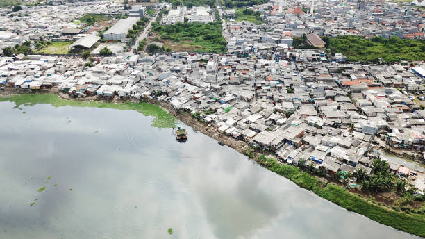 Aerial view of slum neighborhood on lakeside Aerial view of slum neighborhood on the lakeside with crowded slum houses at North Jakarta, Indonesia jakarta slums stock pictures, royalty-free photos & images