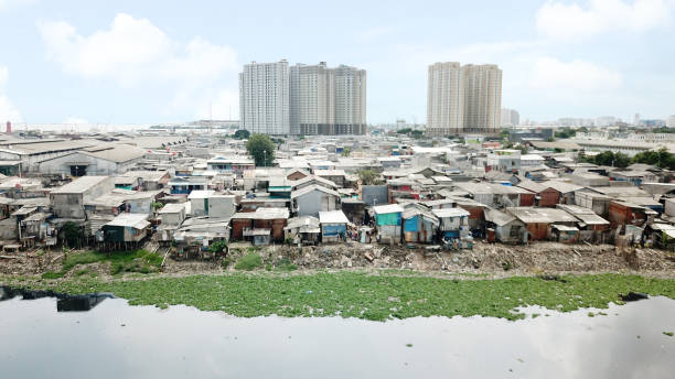 Aerial view of crowded slum neighborhood Aerial view of crowded slum neighborhood on the lakeside with apartment building background at North Jakarta, Indonesia jakarta slums stock pictures, royalty-free photos & images