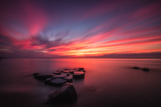 istock Beautiful colors explode in the sky during an intense sunset over water 1013961398