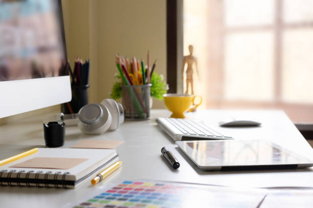 istock Side view Modern office workplace with digital tablet, notepad, colorful pencils, computer in morning. 1013963746