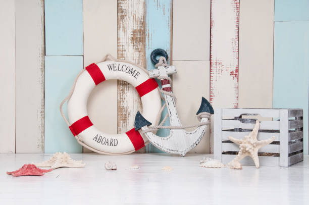 Composition on a marine theme with an anchor and life buoy, seashells and starfish on a wooden background stock photo